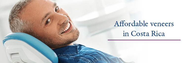 Woman in dental chair comparing shades of dental veneers
