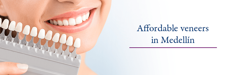 Woman in dental chair comparing shades of dental veneers